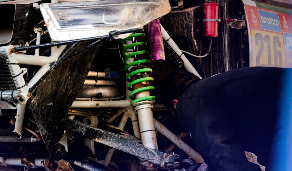 Mechanic working on the suspension of an off-road race vehicle