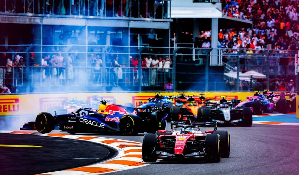 Ferrari and Red Bull cars navigating the opening corners of the 2026 Miami Grand Prix with the Red Bull spinning and smoke visible.