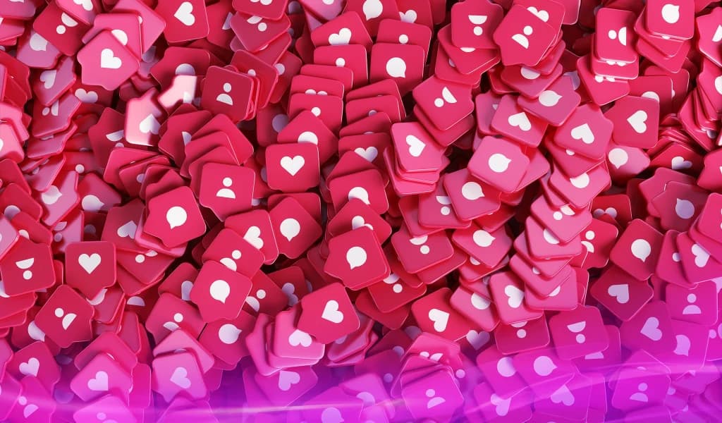 Pile of pink social media icons with hearts, comments, and profile symbols filling the frame.