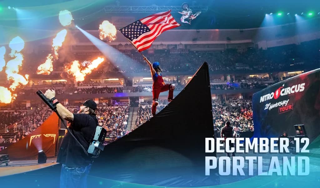 Man stands on a steep ramp in an arena, waving a large American flag as flames erupt, with text reading “December 12 Portland”.