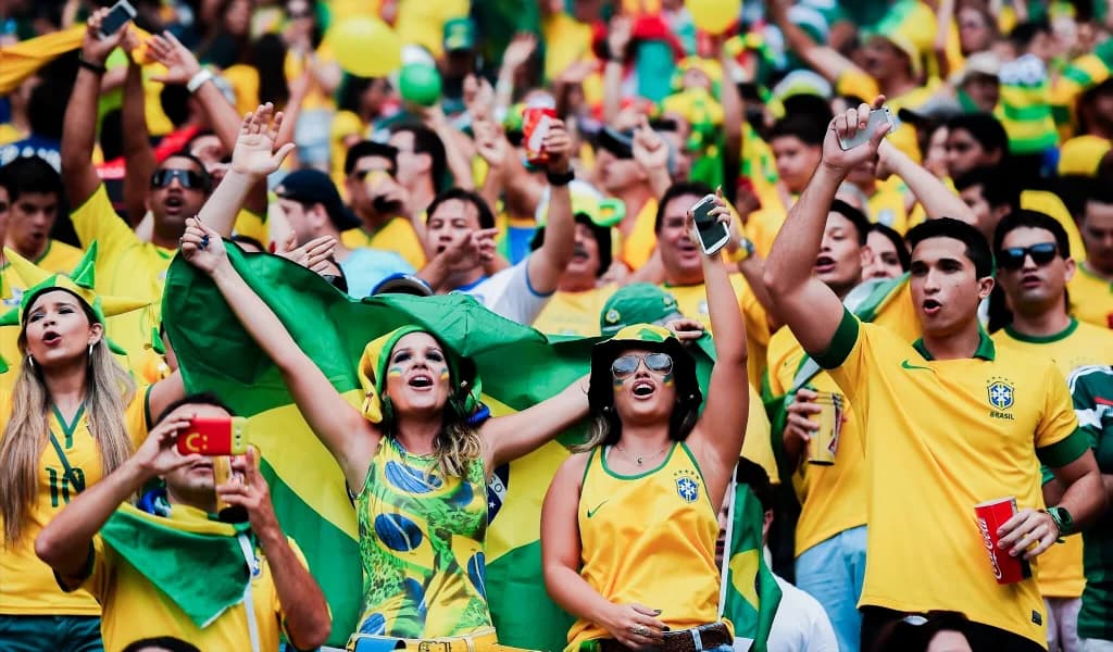 Hands lifting the World Cup trophy below flag badges for France, Argentina, Spain, England, and Brazil.