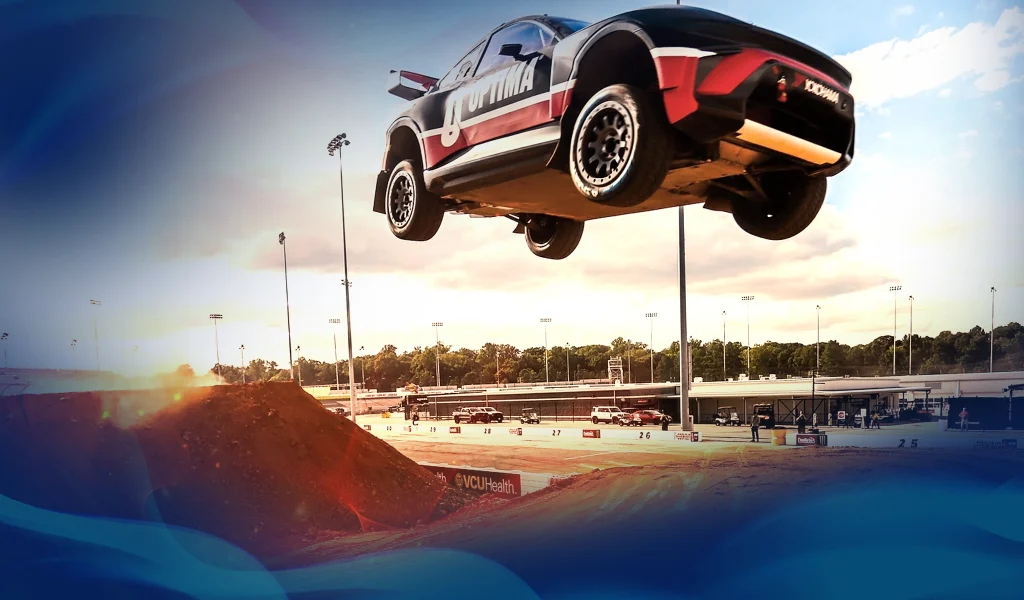 An evo car flies through the air off a ramp at Nitrocross rallycar racing series in Richmond, Virginia