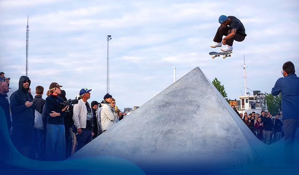 Dashawn Jordan performing a skateboard trick in front of a crowd.