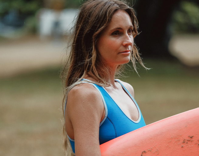 Alana Blanchard, professional surfer holds a surfboard in Hawaii on the set of The Team Ignition Show