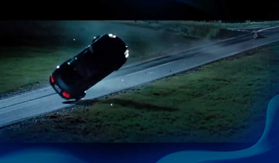 A car flips dramatically in mid-air during a high-speed chase on a dark, isolated road at night.