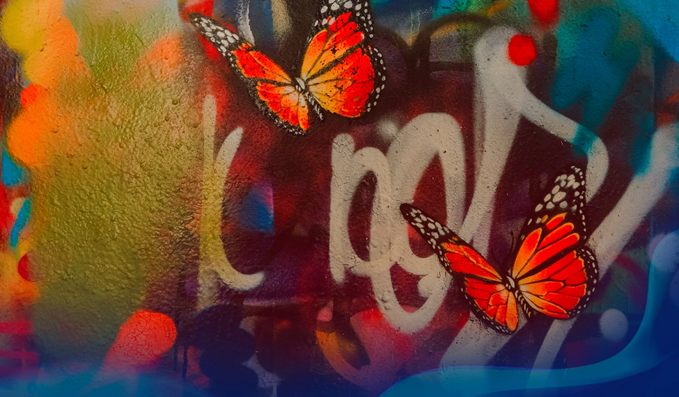 Two orange and black butterflies painted on a colorful graffiti wall with abstract shapes.